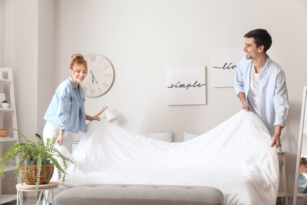 Man and Woman Making Up a Spare Bed For Guests