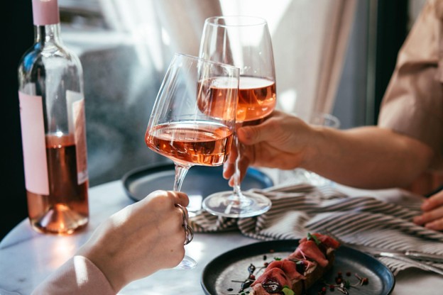 Two People Cheering Their Wine Glass at Dinner